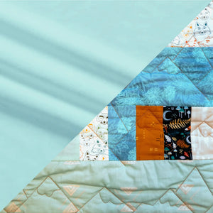 Bricks and Beams Quilt Kit Timberline turquoise patchwork with blue floral blocks and orange accents