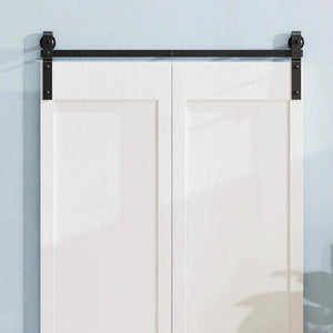 Bi-fold sliding barn door hardware track kit in black metal (no door) mounted above white double doors.