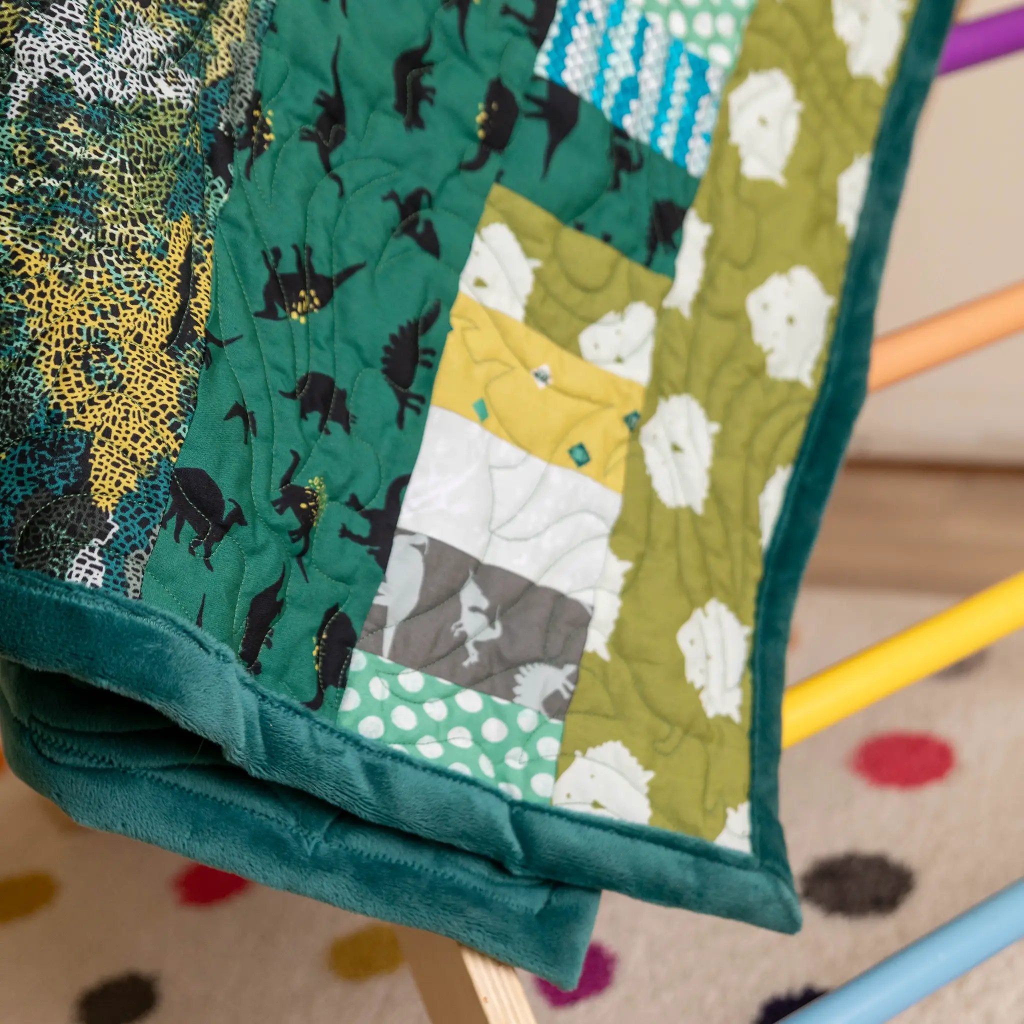 Quilt Kit Bricks and Beams Dinosaurs by Block Party Quilt Co; green dinosaur print fabrics with teal border