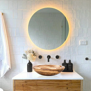 Brown onyx translucent above-counter vessel sink atop white bathroom vanity countertop.