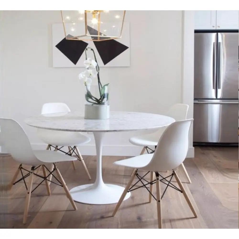 Round marble dining table by Villohome, polished surface with eased edge, white molded chairs with wooden legs