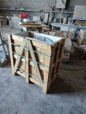 Carrara white marble nesting coffee table set of 2 with round polished tops in a wooden shipping crate