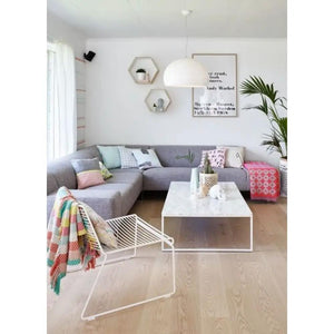 Marble coffee table, rectangular with polished eased edge, white metal base in a bright living room.