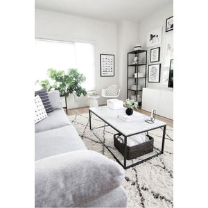Marble coffee table, rectangular with a polished top and eased edges, black metal frame.