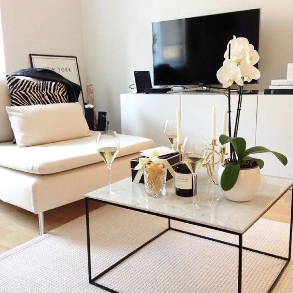 Marble coffee table square with polished and eased edge, black metal frame, in a modern living room.