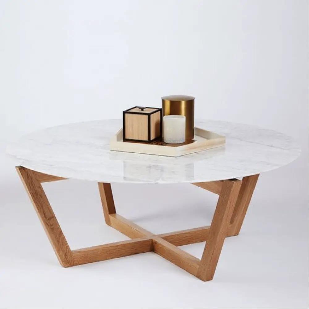 Carrara white marble round coffee table with a polished edge and wooden X-frame base.