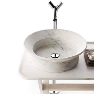 Natural stone marble bathroom sink; round white vessel on a vanity with a chrome faucet.