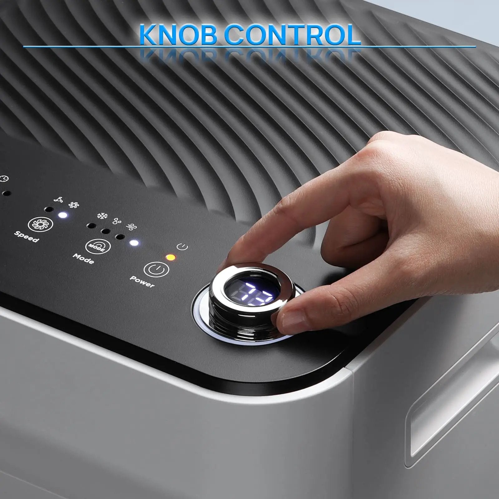 TURBRO Finnmark 10,000 BTU portable air conditioner control panel with a large chrome knob being pressed by a hand