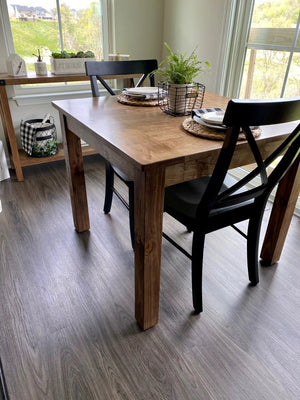 2x Single X Chair with black X-back and wooden legs at a wooden dining table