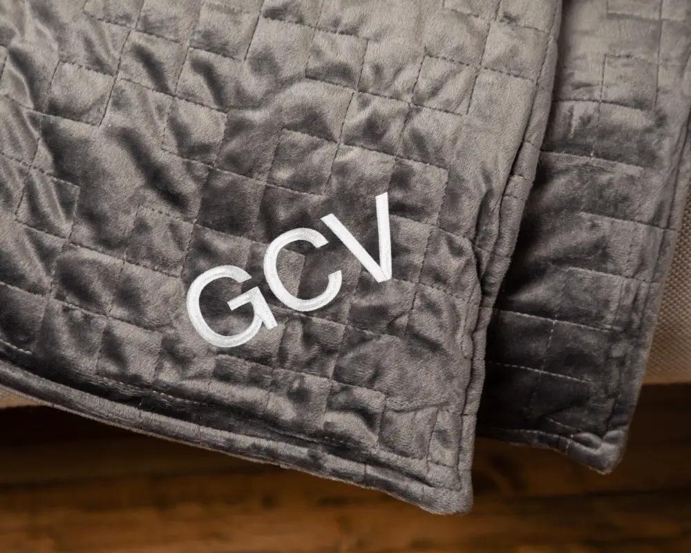 Original Weighted Blanket by Gravity Blankets; dark gray quilted fabric with GCV embroidery