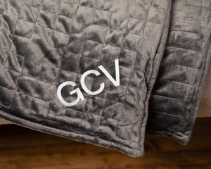 Original Weighted Blanket by Gravity Blankets; dark gray quilted fabric with GCV embroidery
