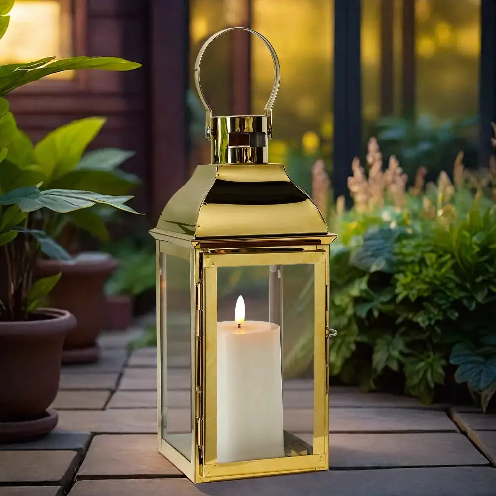 Gold stainless steel decorative candle lantern by JHY DESIGN with glass panels and loop top, candle inside.