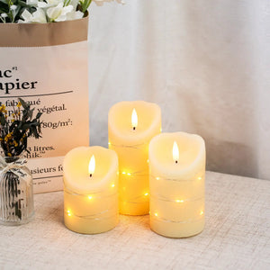 Set of 3 cream wax LED candles with flickering flames and warm glow, wrapped with string lights.