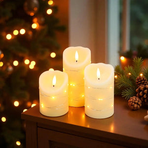 LED candles: Set of 3 flickering flameless real wax LED candles, warm white on a wooden table with holiday lights