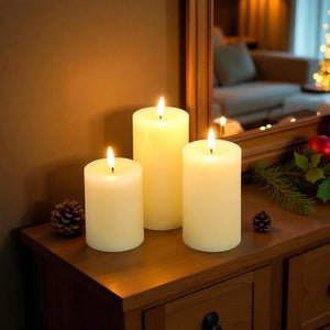 Set of 3 white LED flameless candles with flickering flames on a wooden console