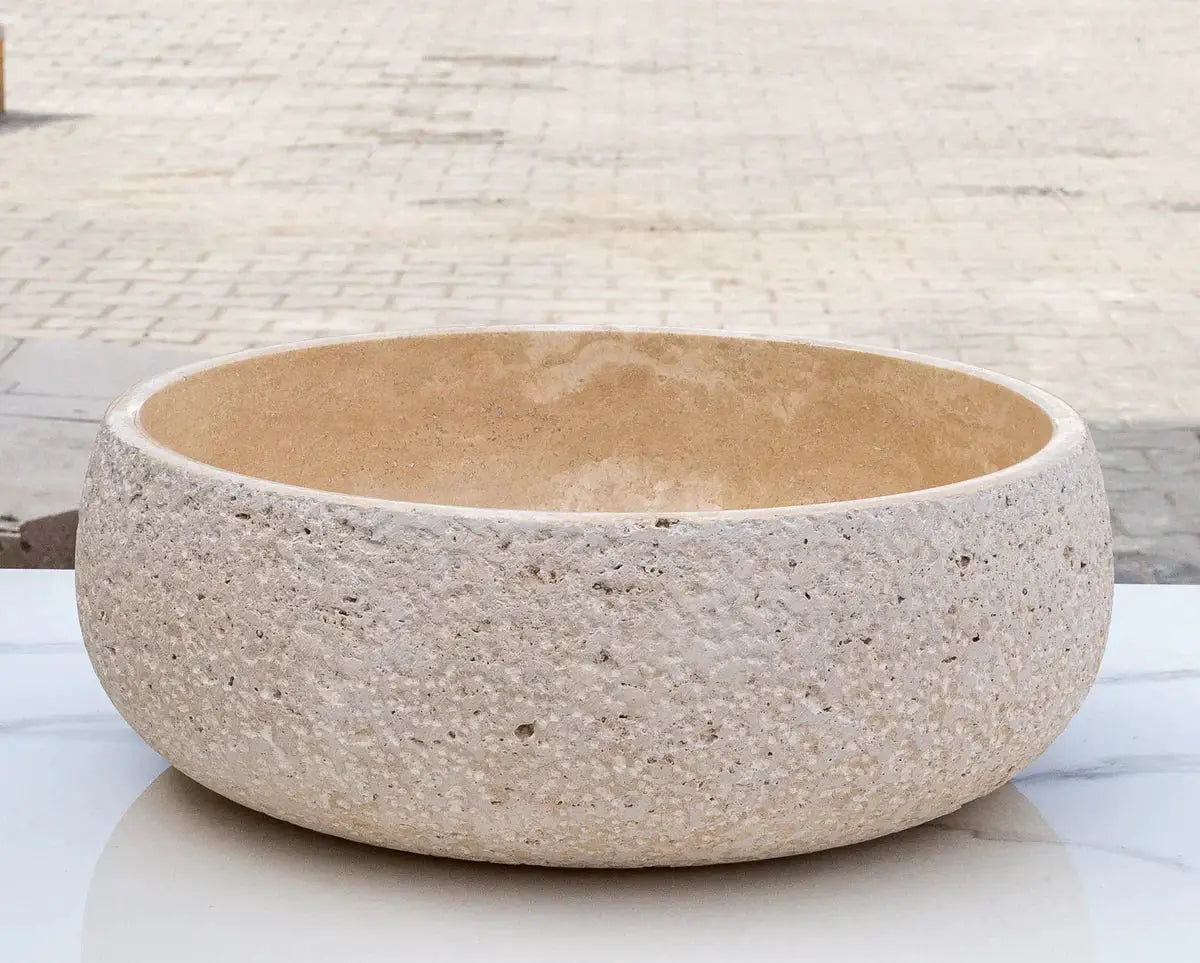 Light beige travertine vessel sink for above-counter vanity; round bowl with rough exterior and smooth interior, 16in dia x 6in high