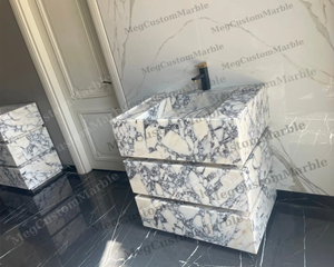 Freestanding vanity in Calacatta Viola marble with purple/gray veins and matte black faucet with gold MegCustomMarble.