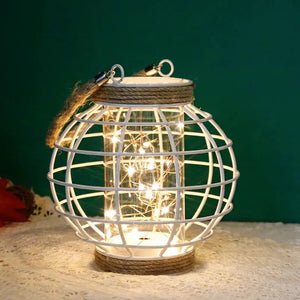 7.3-inch high white metal cage LED lantern with rope accents and battery-powered LED lights inside.