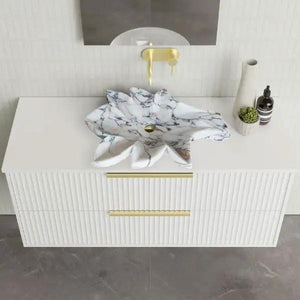 Calacatta Viola marble leaf vanity sink by Villohome on a white ribbed bathroom vanity with gold hardware