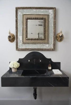 Wall-mount bathroom sink in black marble with a polished backsplash