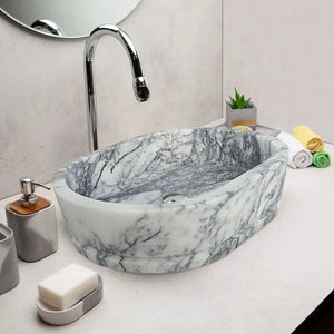 New York Marble Ellipse wall-mount bathroom sink, gray-veined oval marble basin with chrome faucet on white countertop.