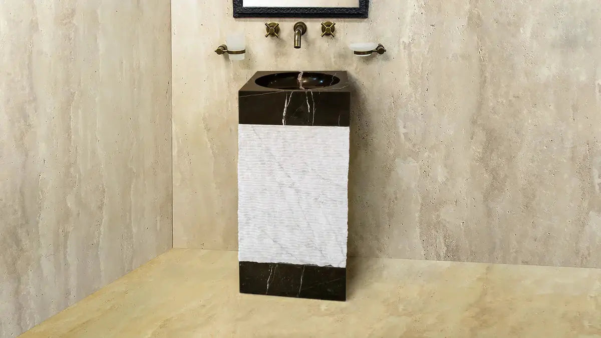 Natural stone 3-piece pedestal sink in black top and base with white Carrara marble panel for standalone bathroom unit.