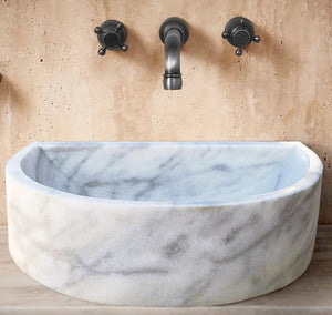 Carrara White marble wall-mount bathroom sink, 24W x 20D x 6H, with black faucet handles.