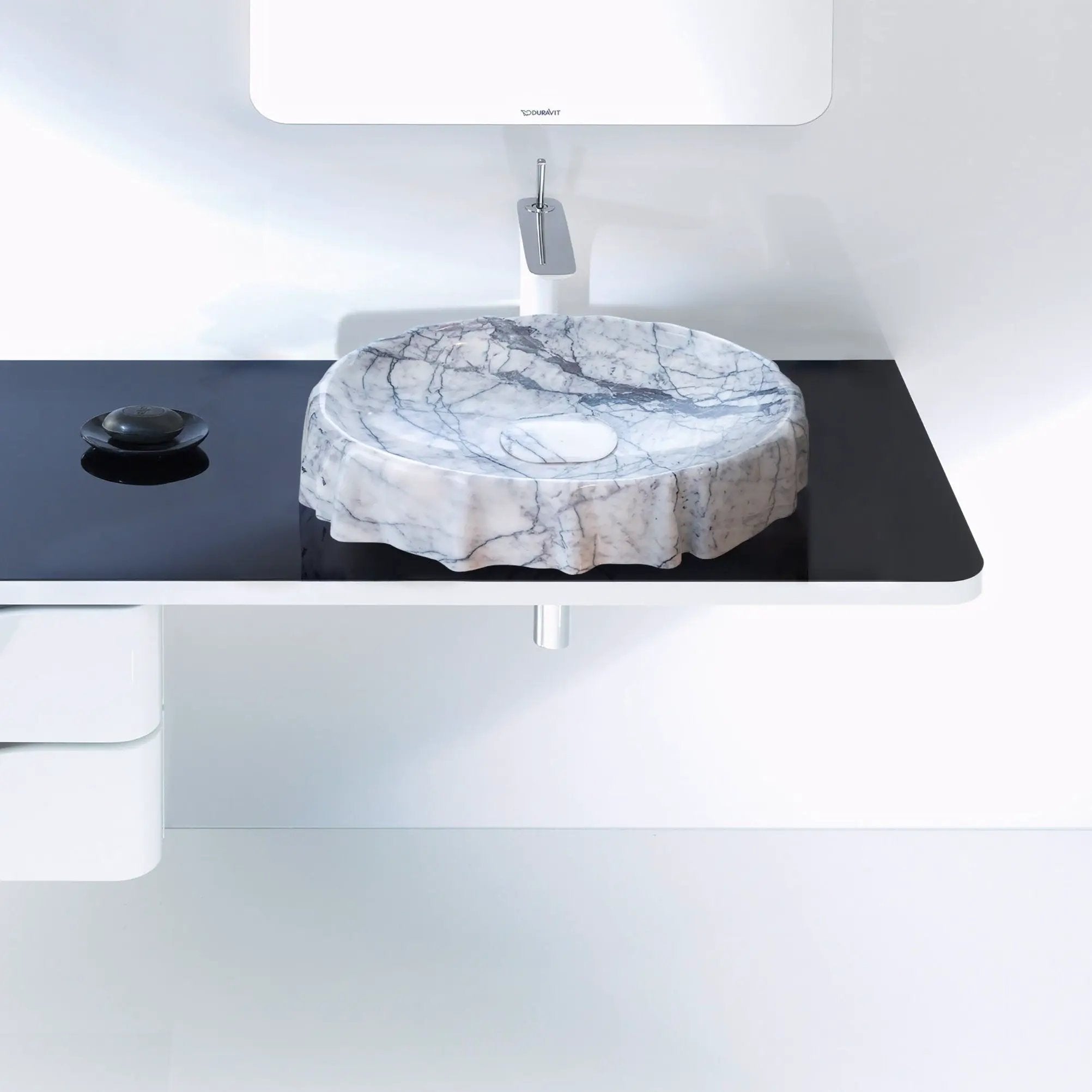 Marble vessel sink on black countertop with chrome faucet; polished New York Marble Designer by Villohome; Duravit logo.
