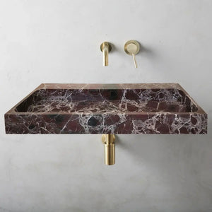 Rosso Levanto marble rectangular wall-mount sink with brass fixtures; dark red stone with white veining.