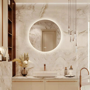 Round backlit LED bathroom vanity mirror with dimmable lights, mounted on a marble wall above the sink