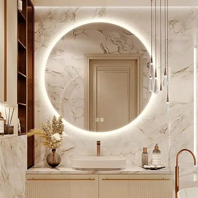 Round LED bathroom vanity mirror with dimmable backlight in marble bathroom featuring a soft glow and gold fixtures