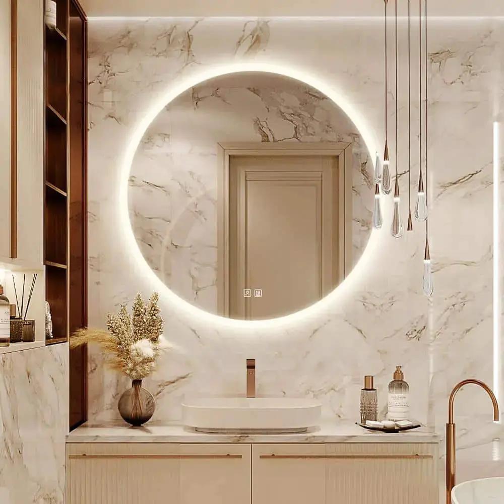 Round LED bathroom vanity mirror with dimmable lights by HAUSVITA, mounted on marble wall with gold faucet