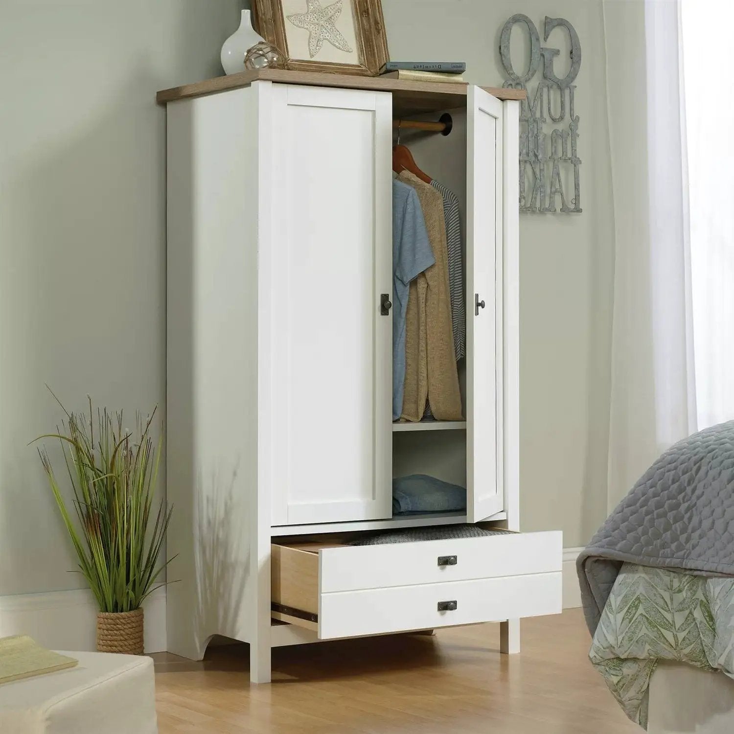 Farmhouse white armoire cabinet with wood top, two doors, and two bottom drawers.