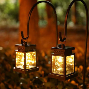 Set of 2 solar lantern lights with black metal frames and warm golden glow, hanging outdoors by JHY DESIGN