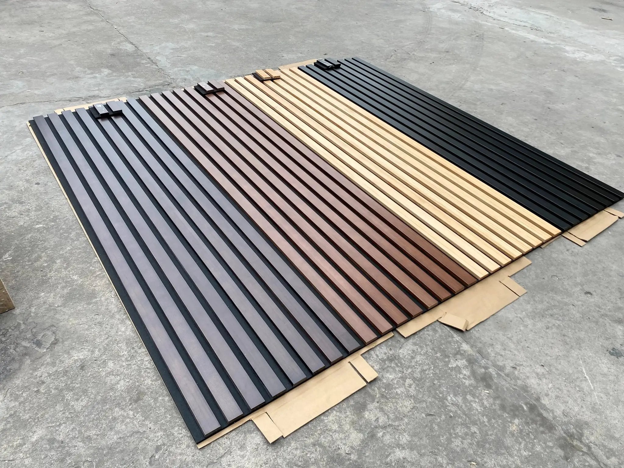 HAUSVITA solid wood acoustic slat wall panels (Broad Strip) sample bundle in dark gray, brown, natural wood, and black.