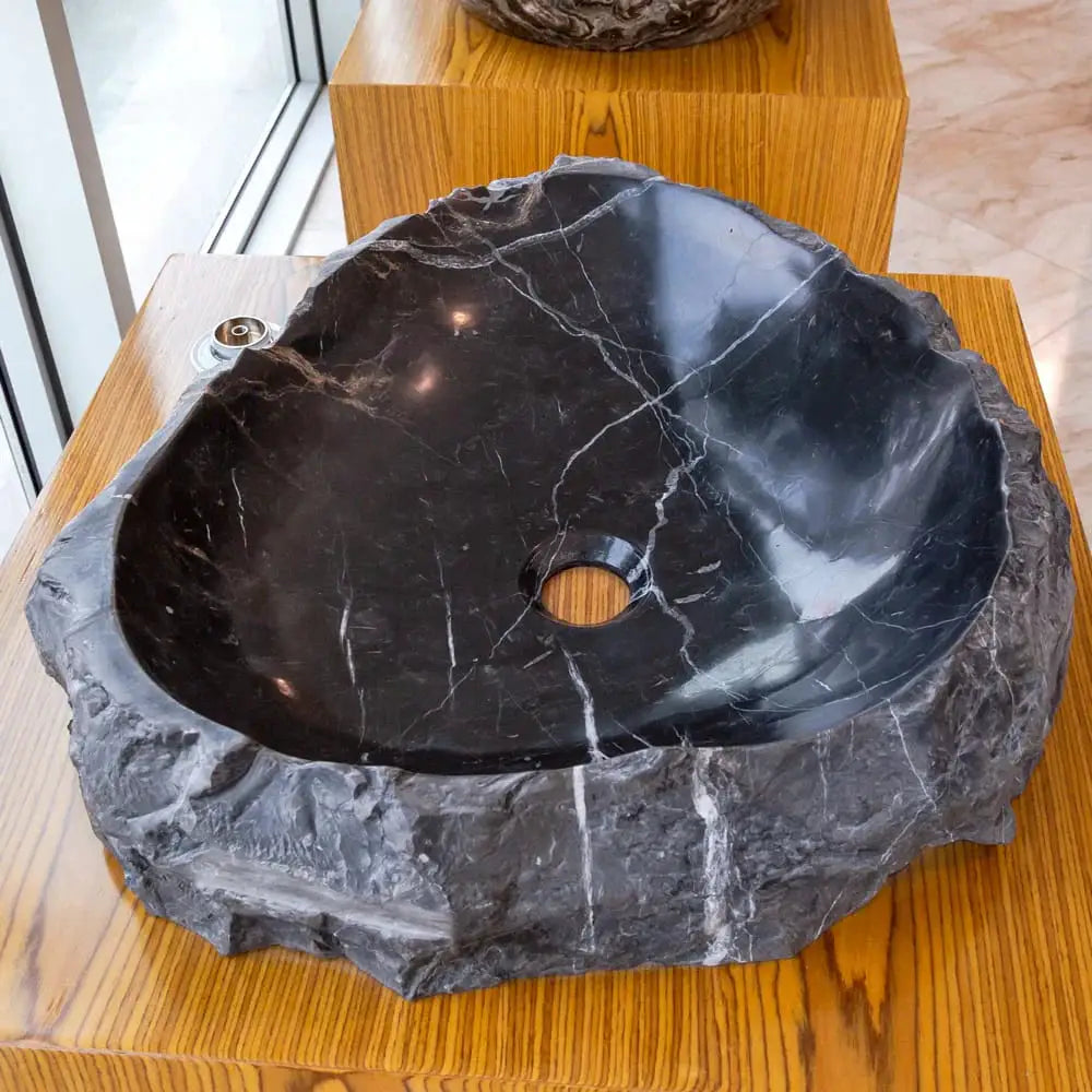 Toros black natural stone marble bathroom sink; rustic oval basin with white veining on wood.