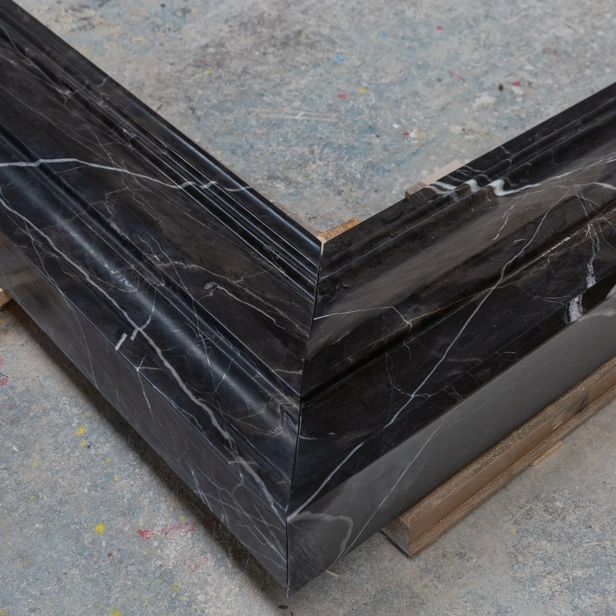 Toros black marble fireplace mantel by Villohome, hand-carved and polished with white veining.
