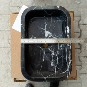 Toros black marble rectangular wall-mount bathroom sink with white veining, viewed from above with ruler for scale.