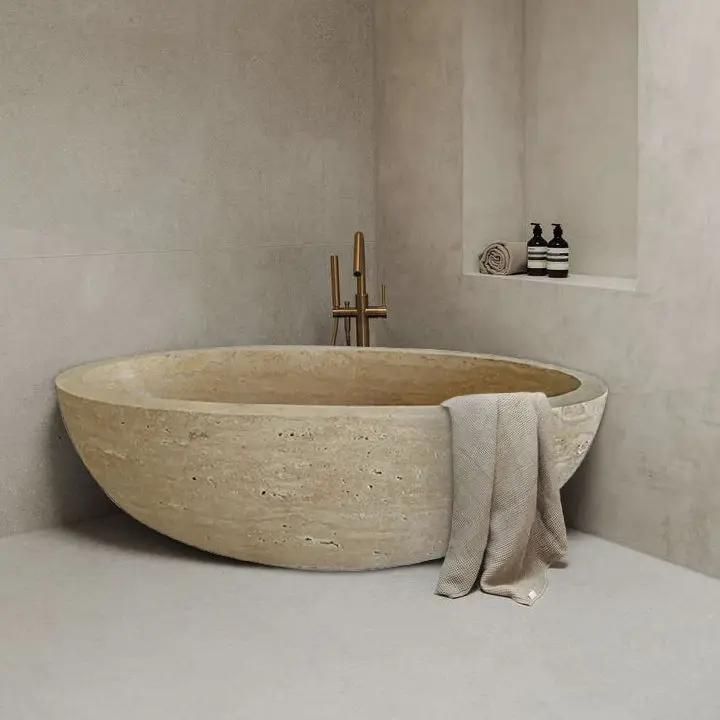 Troia Light Travertine bathtub by Villohome, hand-carved from solid marble block, beige oval freestanding tub