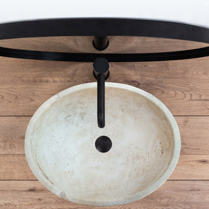 Troia Light Travertine above vanity oval vessel sink on black faucet over wood countertop