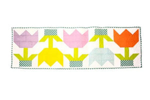 Quilt Kit Spring Tulip Table Runner by Block Party Quilt Co, five vividly colored tulip blocks on white background