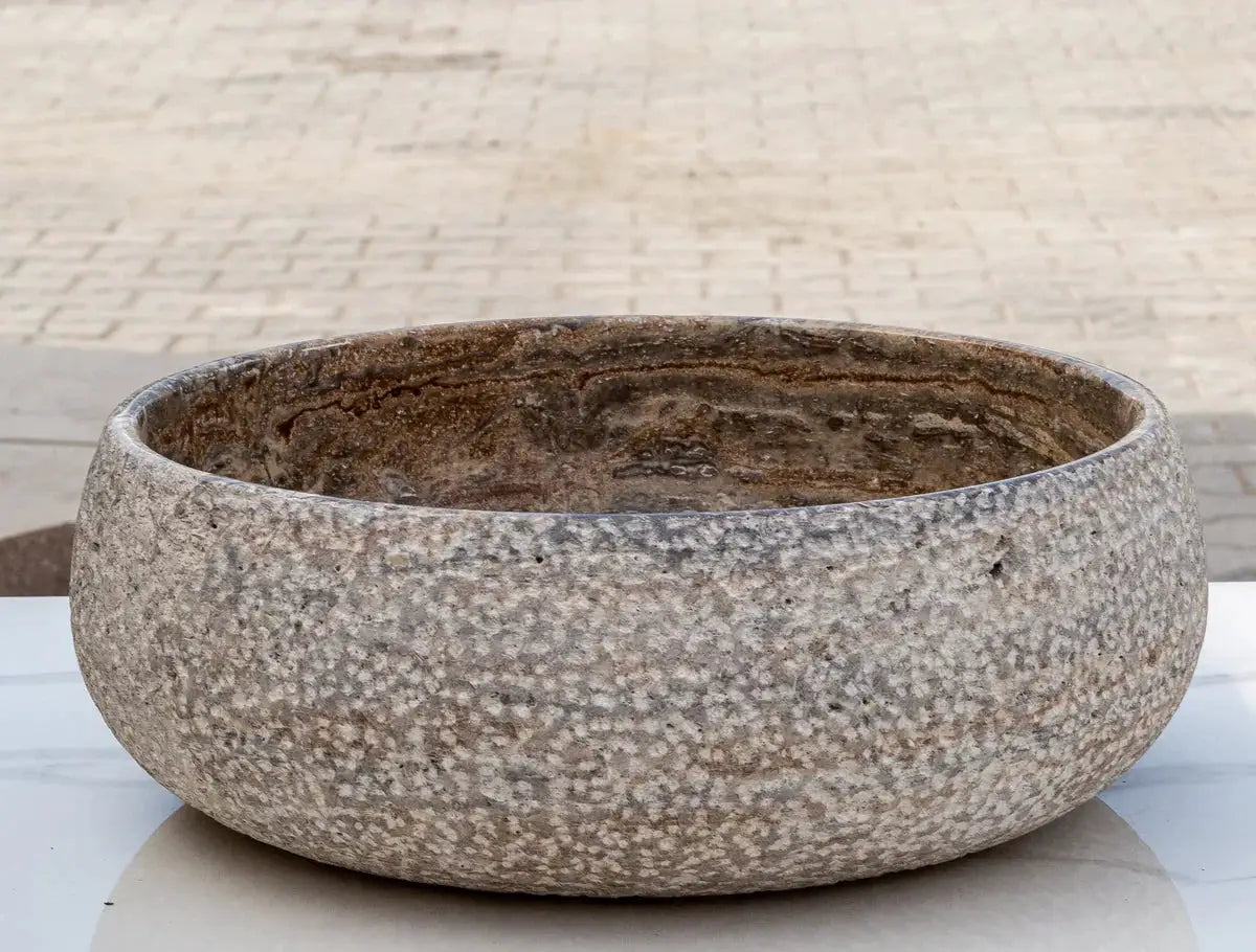 Valencia Travertine above-counter bathroom sink by Villohome, round rustic sand-blasted stone bowl.