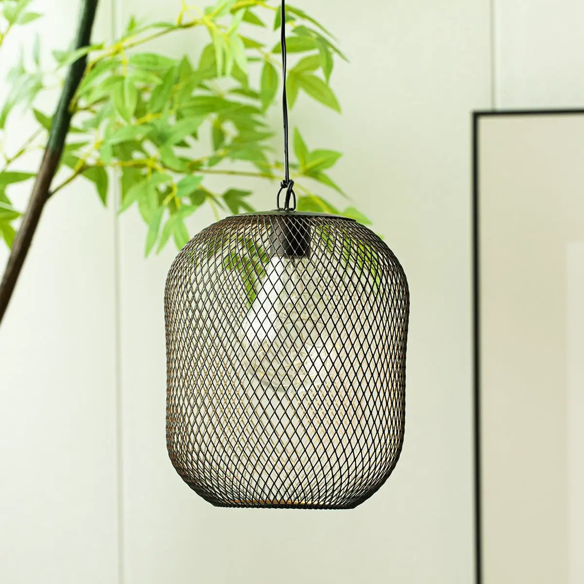 Battery-operated hanging lamp by JHY DESIGN featuring a black metal mesh lantern and bulb