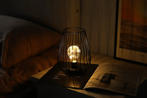 8-inch tall cage-shaped table lamp, battery-powered with a warm glowing bulb by JHY DESIGN