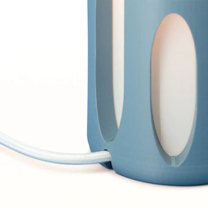Amoeba Table Lamp by Terra Labs, blue base with white oval cutouts and braided cord.