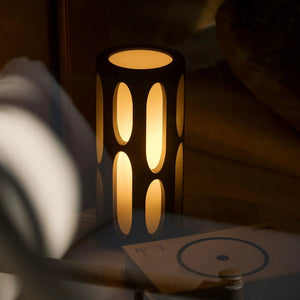 Amoeba Table Lamp by Terra Labs; black metal body with warm amber glow through oval cutouts.