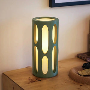 Amoeba Table Lamp by Terra Labs; teal ceramic lamp with oval cutouts, warm glow.