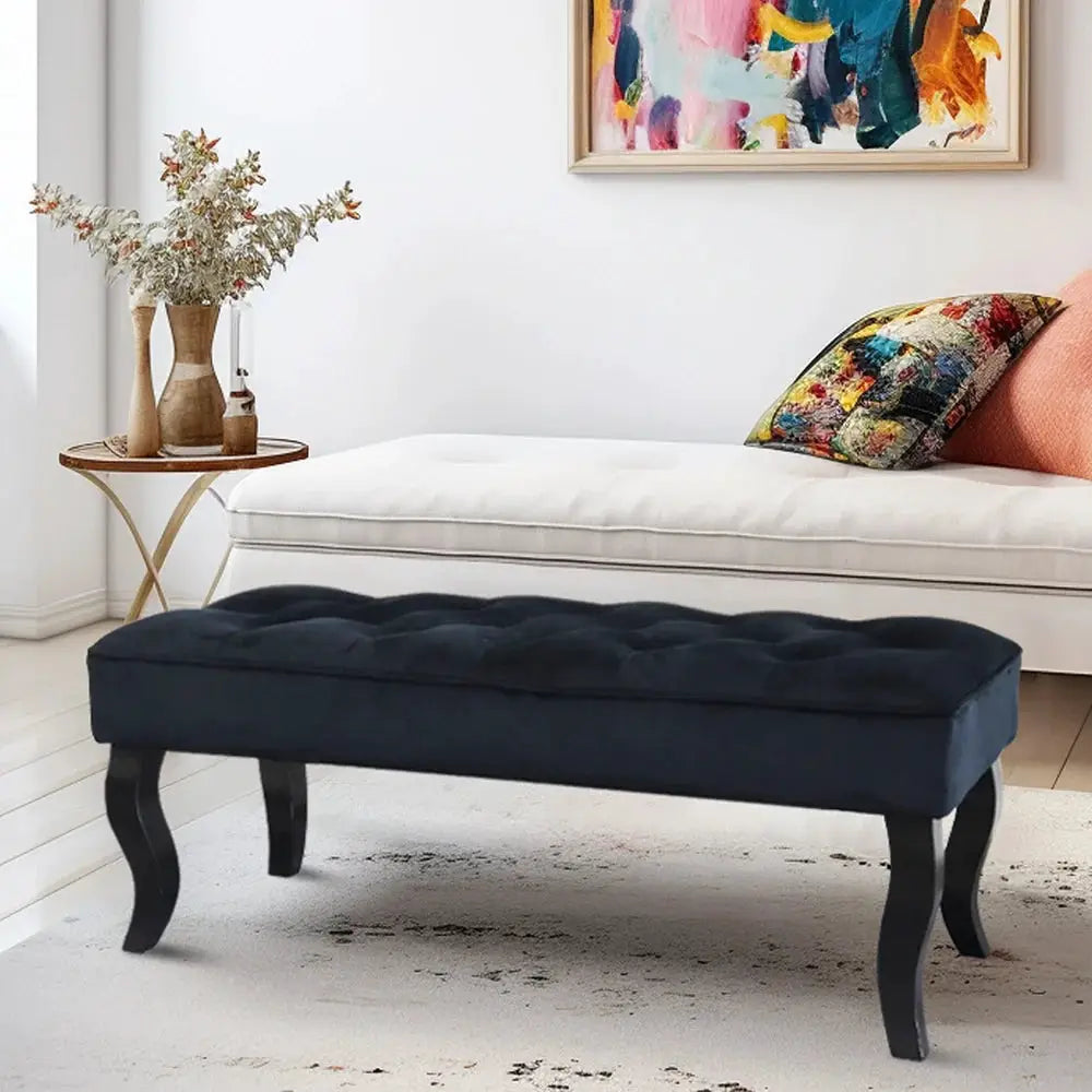 Dutch velvet ottoman bench, navy tufted fabric with curved black legs.