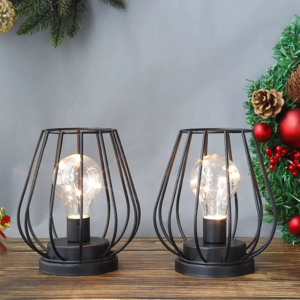 Set of 2 black metal battery-operated lamps with cage-style frames and exposed bulbs, 7 inches tall