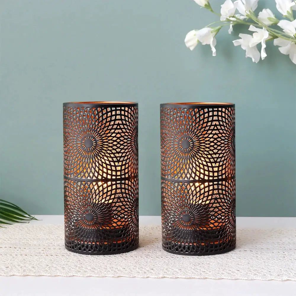 Battery-powered table lamps set of 2; black metal cylindrical lanterns with intricate radial geometric pattern and warm glow.